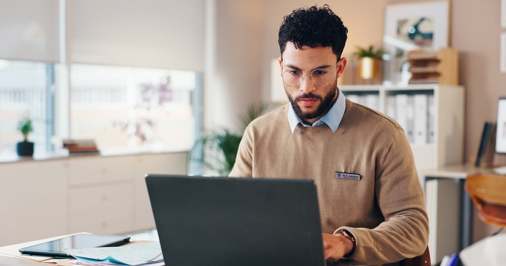 Male medical records specialist working on computer