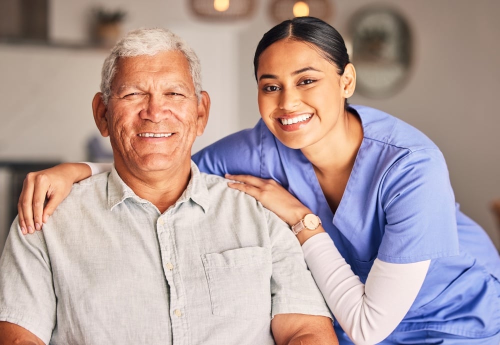 Female home health aide smiling with older male patient